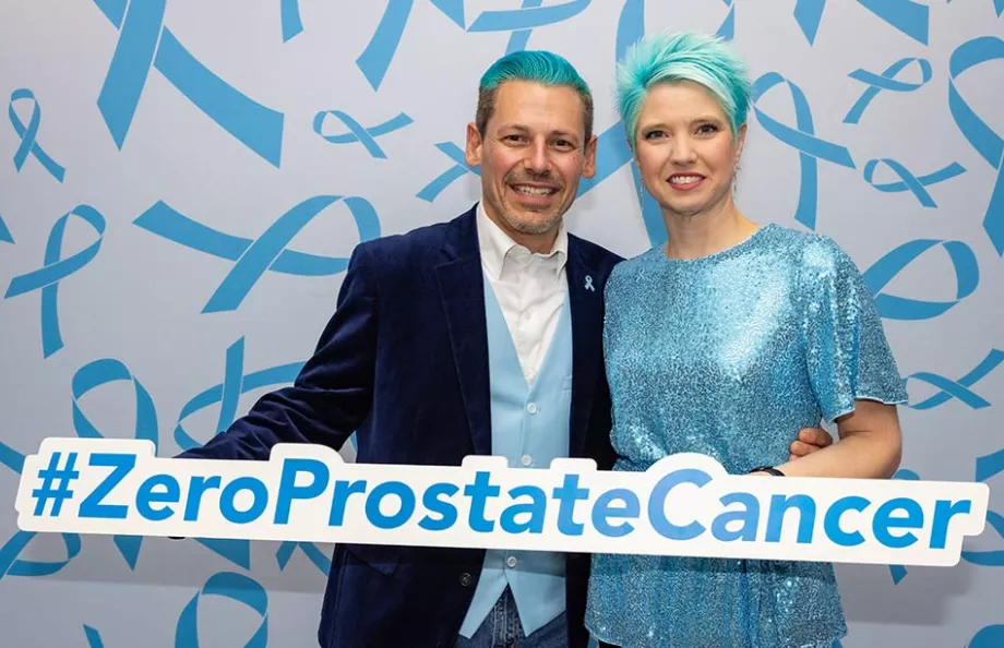 Man and woman with blue hair holding sign that says #ZeroProstateCancer