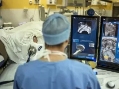 A doctor in a medical room with a monitor up showing images of someone's prostate