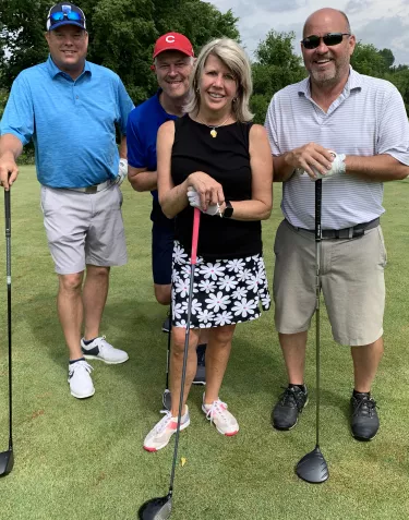 A group of people with golf clubs