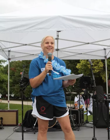 blond woman dressed up in sports clothes giving a speech