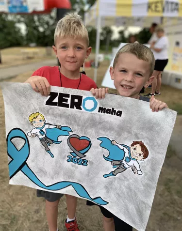 Kids holding a ZEROmaha banner