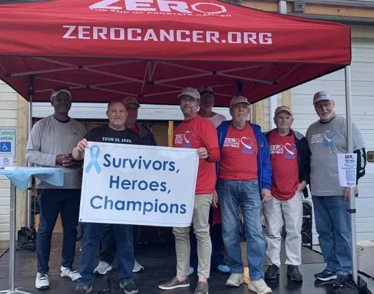 Group of men holding a Survivors & Heroes sign