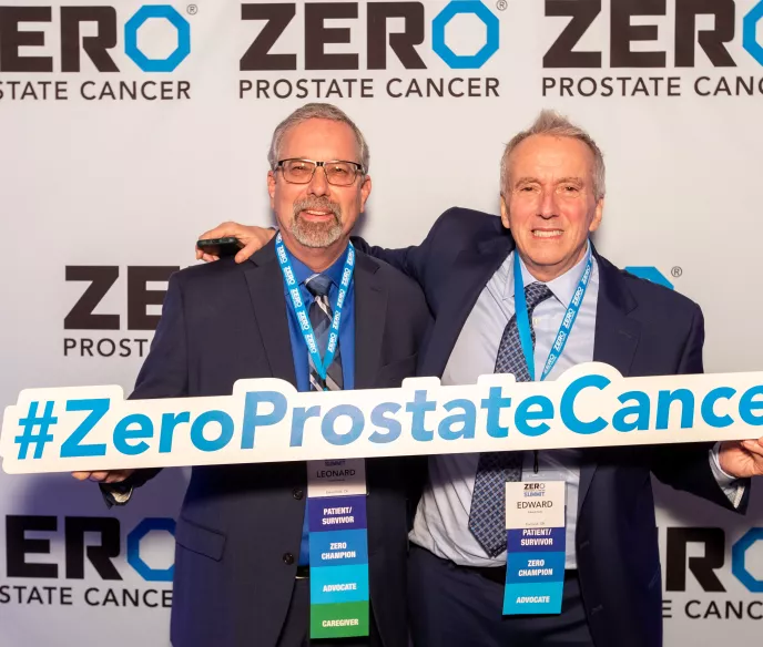 Two middle-aged white men holding a ZERO Prostate Cancer sign