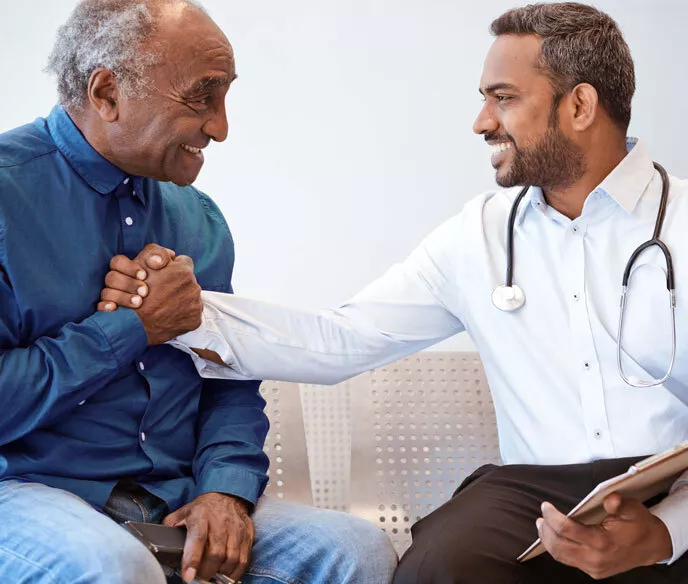 A physician engages in conversation with an elderly gentleman, providing medical advice and support.