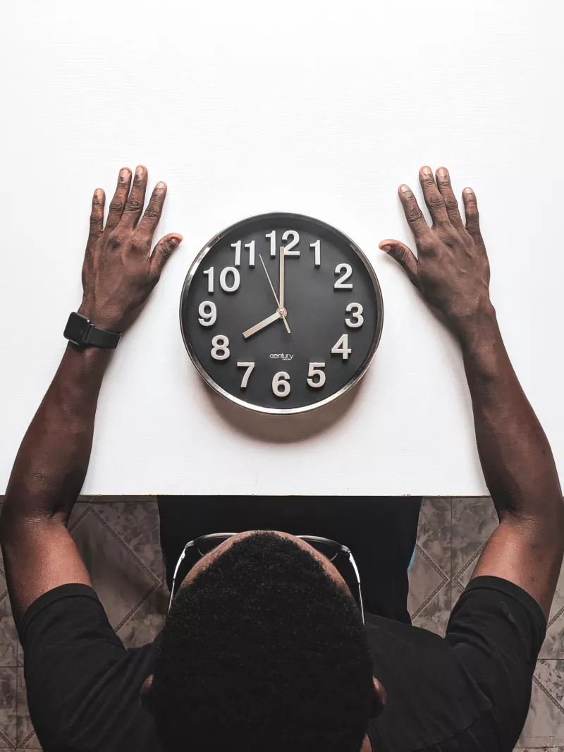Black male looking in at clock