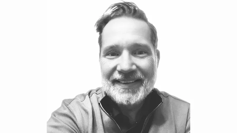 Man in grayscale selfie image smiling