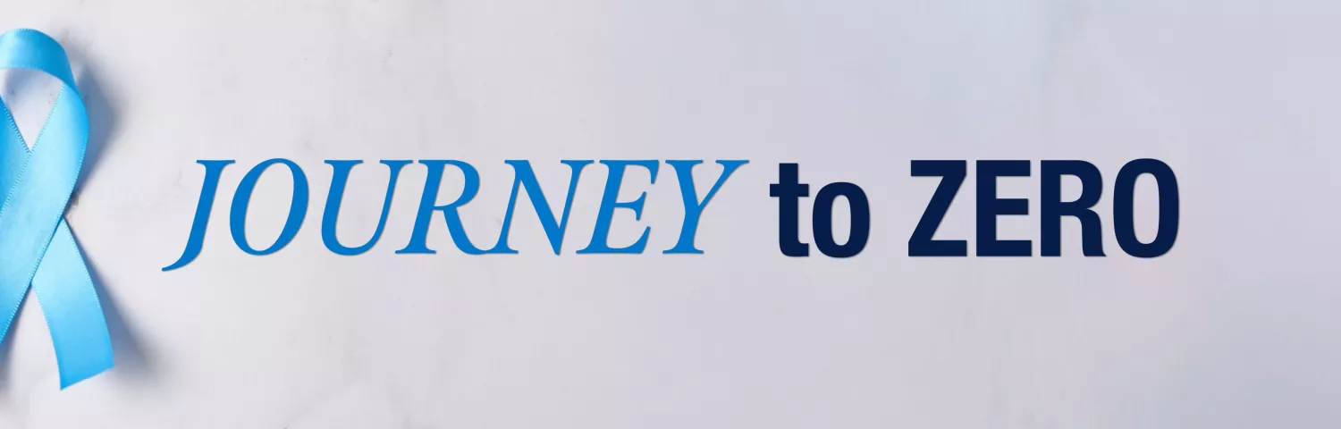 A light blue awareness ribbon is positioned on the left side of a white background, next to bold text that reads "JOURNEY to ZERO". The ribbon and text appear to be part of a banner or header image. The blue ribbon commonly represents prostate cancer awareness, and the text suggests a campaign aimed at reaching zero cases or deaths.