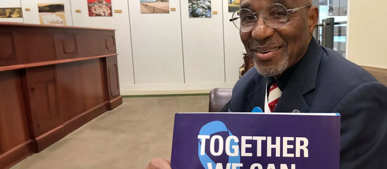 Man holding sign that says Together we can END prostate cancer