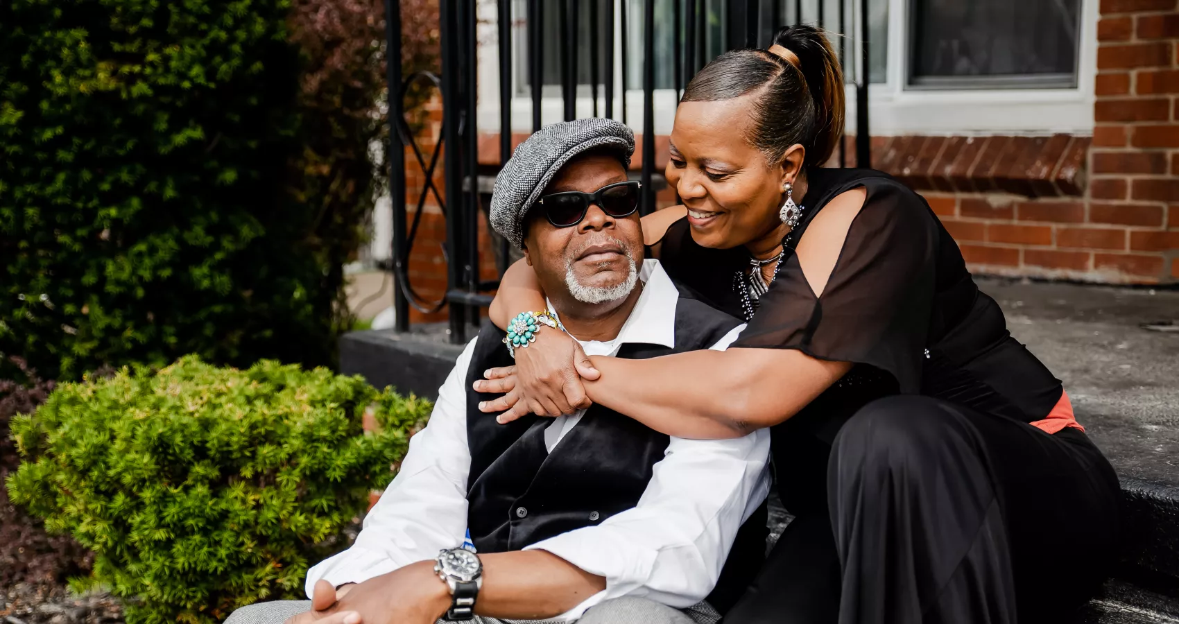 African American heterosexual couple sitting on a porch and hugging