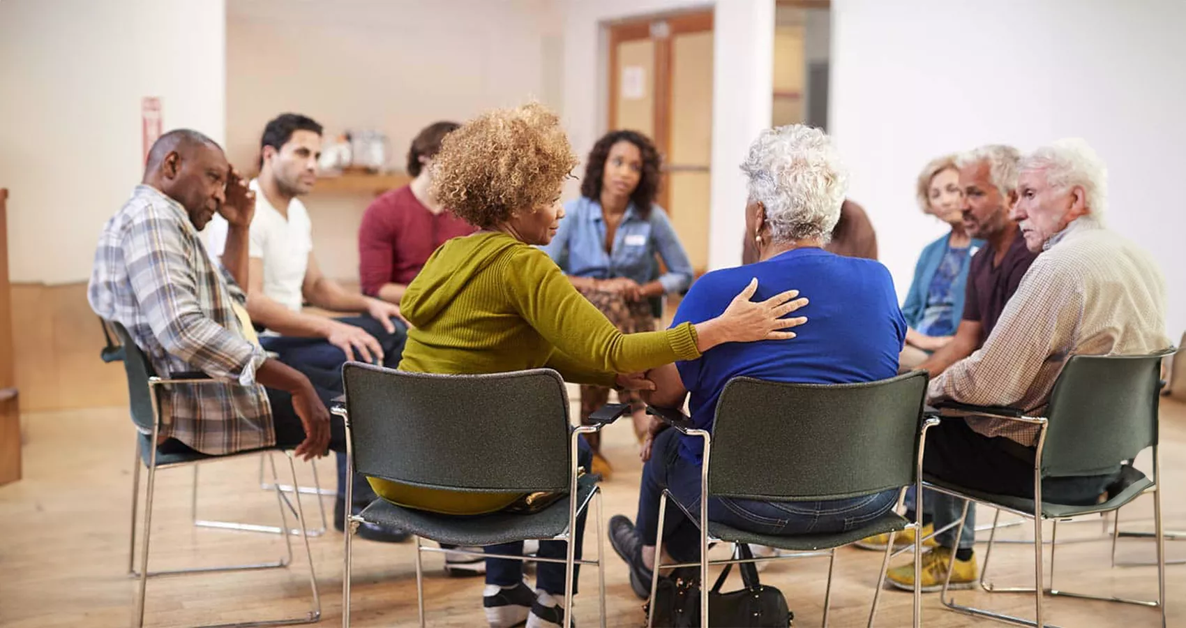 A mixed group of older men and women sitting in a circle at a support group