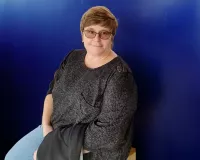 ZERO360 Case Manager, Beth Scott sitting in front of a blue background