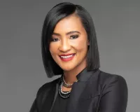 African American woman with a slick haircut and wearing black suit