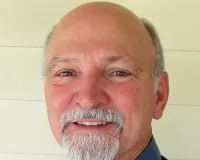 Bolding middle-aged man with grey beard