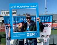 Man and woman posing with a blue photo frame