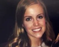 Young woman with auburn long hair smiling at the camera