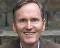 A Caucasian man in a brown suit