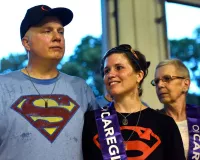 A tall man in a Superman t-shirt hugging a woman next to him
