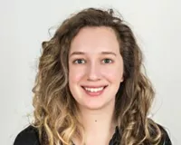 Headshot of a young woman with curly hair—Brianna Abbott, health reporter at the Wall Street Journal