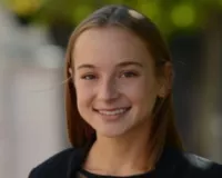 Blonde woman wearing a black shirt, headshot from the shoulders up