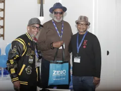 Three people smiling and standing shoulder to shoulder