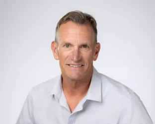 Middle-aged man with grey hair wearing a white shirt