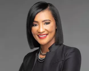 African American woman with a slick haircut and wearing black suit