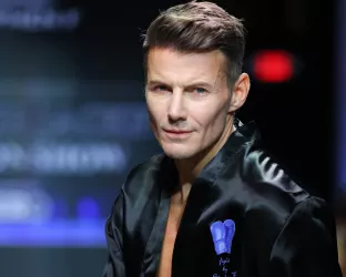 Model wearing a boxing robe and boxing gloves on runway