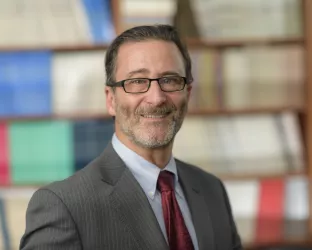 A man wearing a suit and tie standing in a library