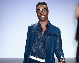 Actor Billy Porter wearing blue denim walking down a runway
