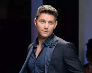 Supermodel, Don Hood, wearing a dark blue suit on the runway