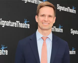 NYC Council Member, Erik Bottcher, wearing a suit and tie at an event