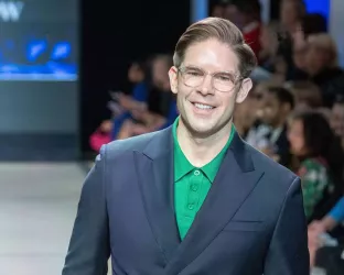 NYC journalist, Frank Dilella, wearing a blue suit and green undershirt