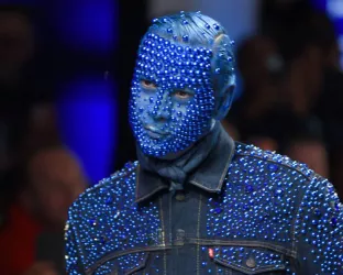 Fashion designer, James Aguiar, with his face painted blue and covered in rhinestones