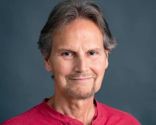 A middle aged white man wearing a red shirt