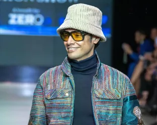 Nightlife Impresario, Omar Hernandez, wearing a colorful outfit and bucket hat