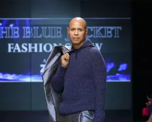 Tao Group Hospitality's Richard Thomas with a jacket slung over his shoulder on the runway