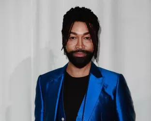 Celebrity Stylist, Ty Hunter, wearing a black shirt with sleek blue pants and blue jacket