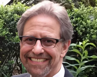 A man in a suit with glasses and gray hair