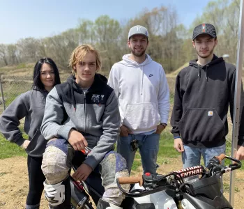 A woman with her three boys pose proud on a motorbike