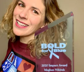 Woman holding a Bold for Blue Award