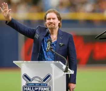 Wade Boggs standing behind a podium that says "Hall of Fame"