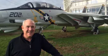 Retired navy Mike Crosby veteran standing in front of a Grumman F-14A Tomcat at the Museum of Flight
