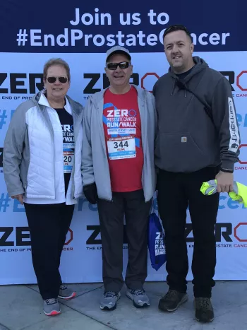 Three people standing at a prostate cancer event 