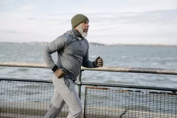 Serious black man running on embankment