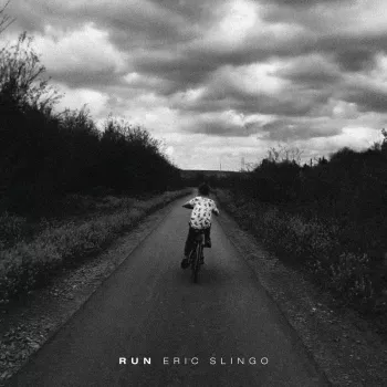 Album art of a kid bicycle racing down a rural road in black in white