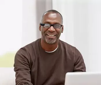 Black man sitting in front of his laptop