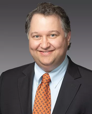 Middle-aged man in a suit smiling at the camera