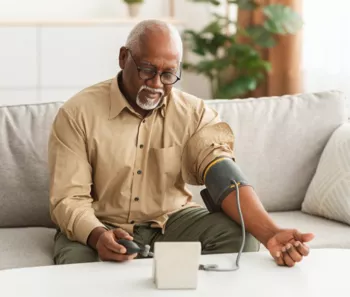 An older Black man taking his blood pressure test
