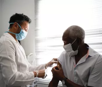 Black man holding up his sleeve for a doctor