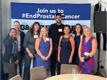 Members of ZERO staff in front of a step-and-repeat